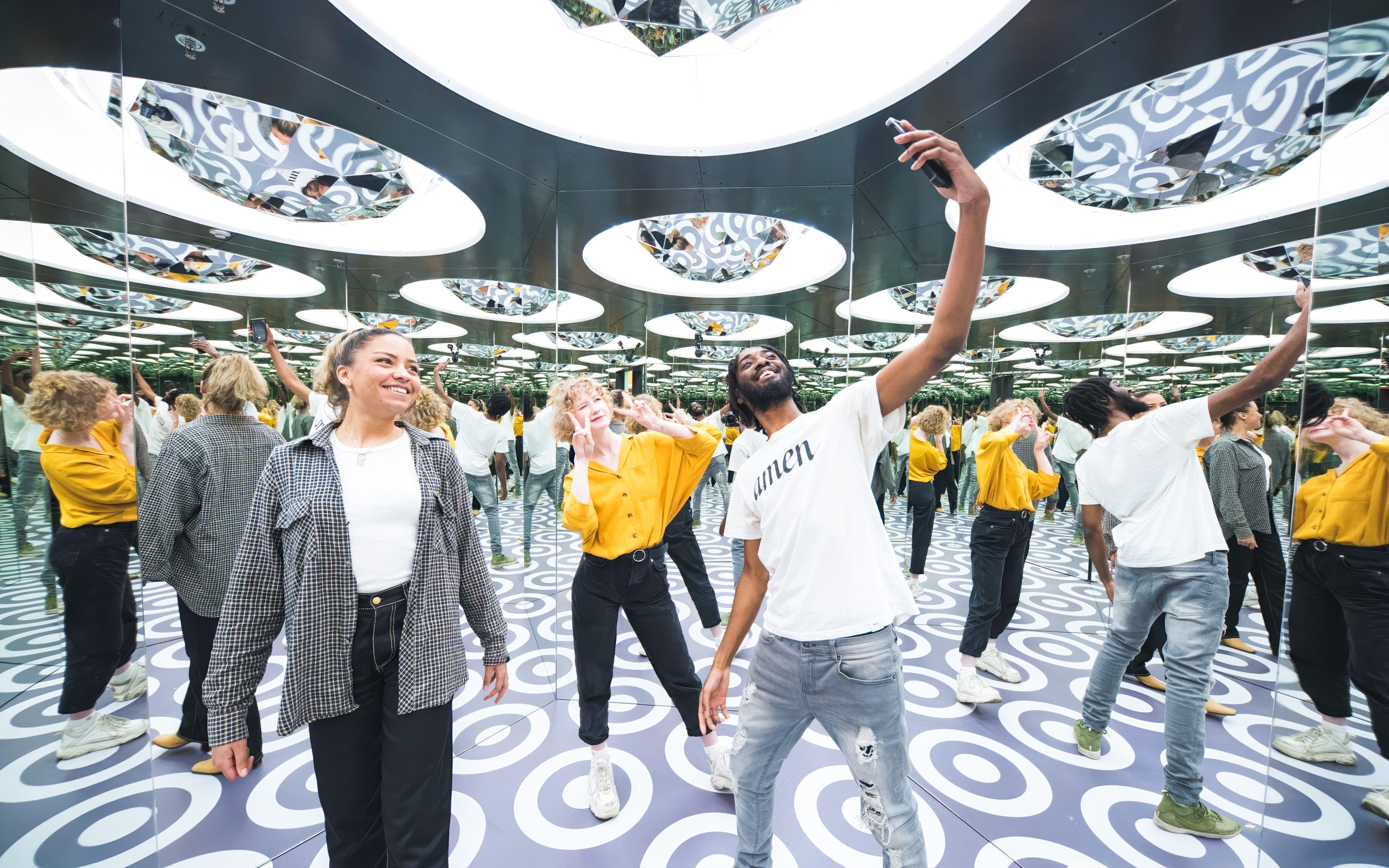 Visitors exploring mirrored room at Paradox Museum Stockholm.
