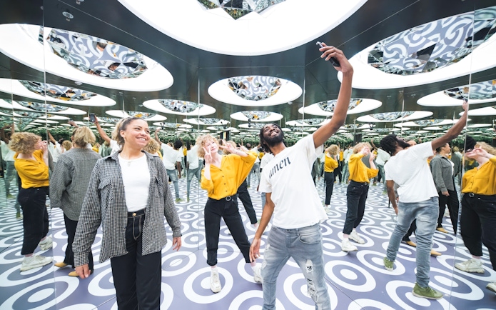 Visitors exploring mirrored room at Paradox Museum Stockholm.