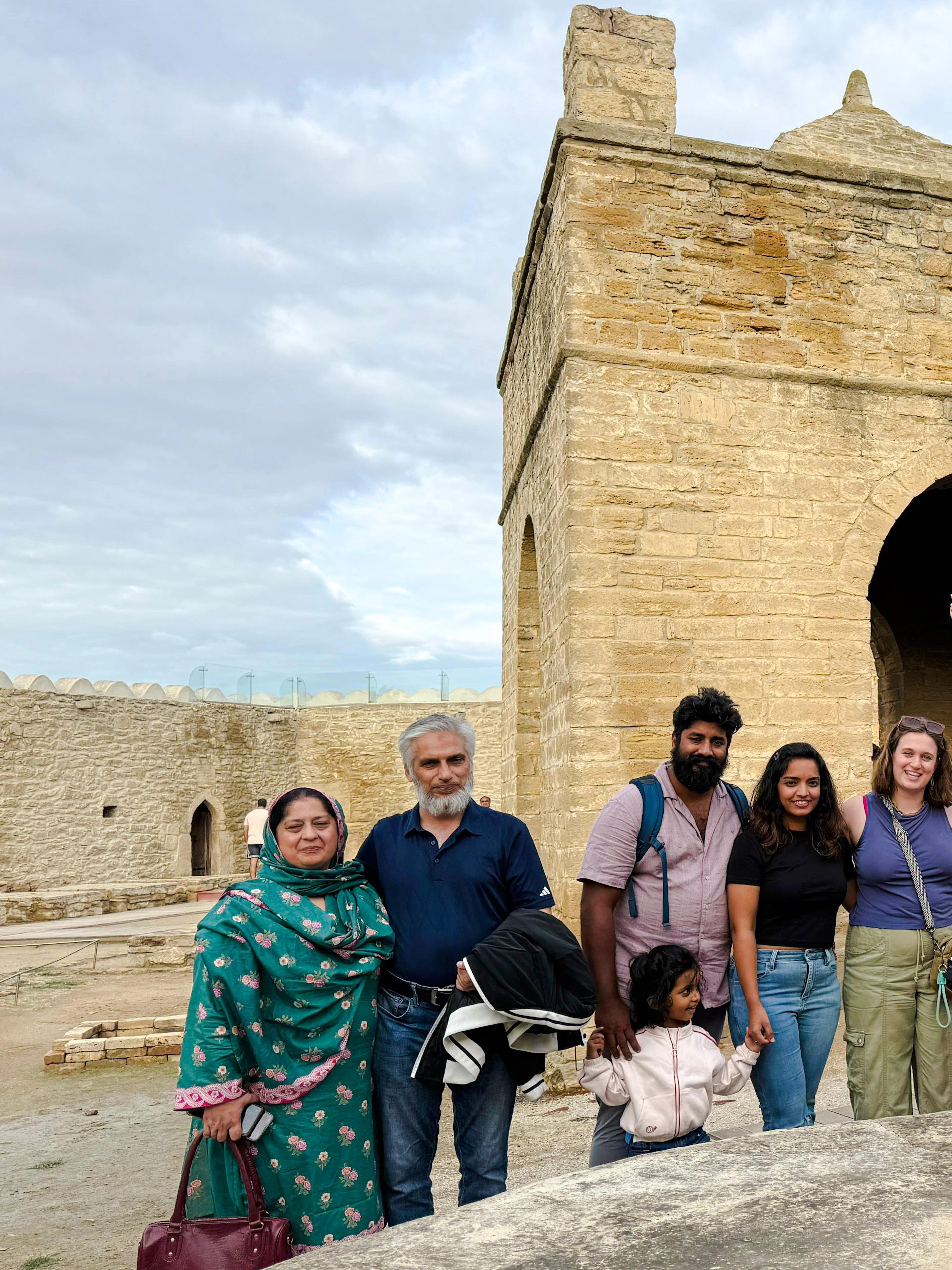 Group of tourists at Ateshgah Fire Temple, Azerbaijan, with flames in foreground.