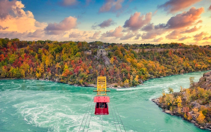 Aerial cable car over Niagara River with autumn foliage in Niagara Falls.