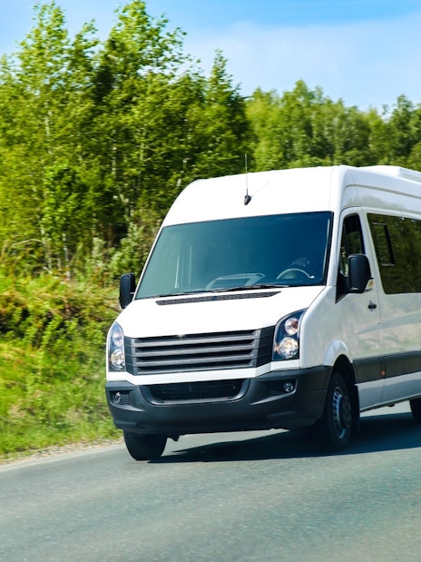 Minibus on road for Gjirokaster day tour transfers.