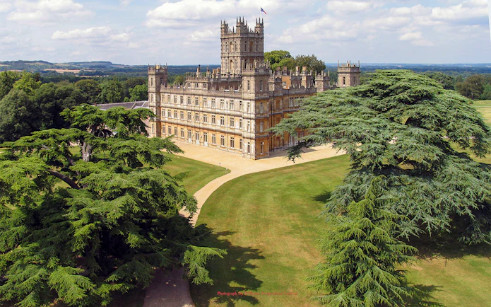 Highclere Castle surrounded by lush gardens, featured in Downton Abbey tours.