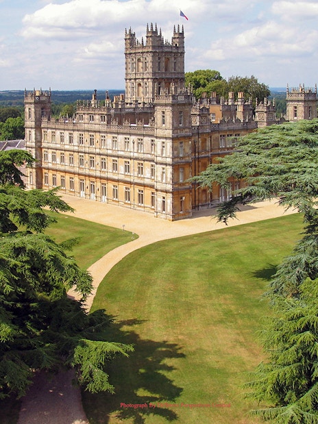 Highclere Castle surrounded by lush gardens, featured in Downton Abbey tours.