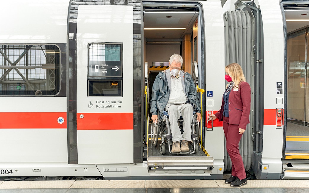Wheelchair user assisted by staff on Eurail train in Germany.