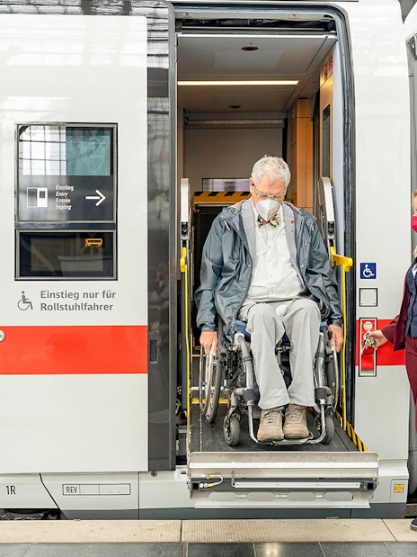 Wheelchair user assisted by staff on Eurail train in Germany.