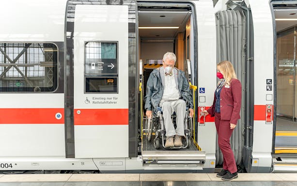 Wheelchair user assisted by staff on Eurail train in Germany.