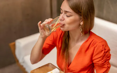 Guest enjoying a refreshing drink at Ame Spa Bali before massage therapy.