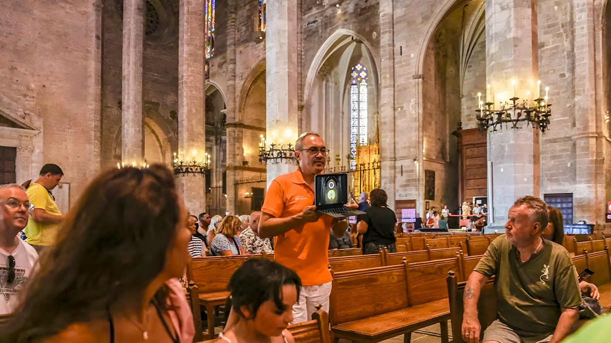 Tour guide explaining to visitors inside Palma cathedral