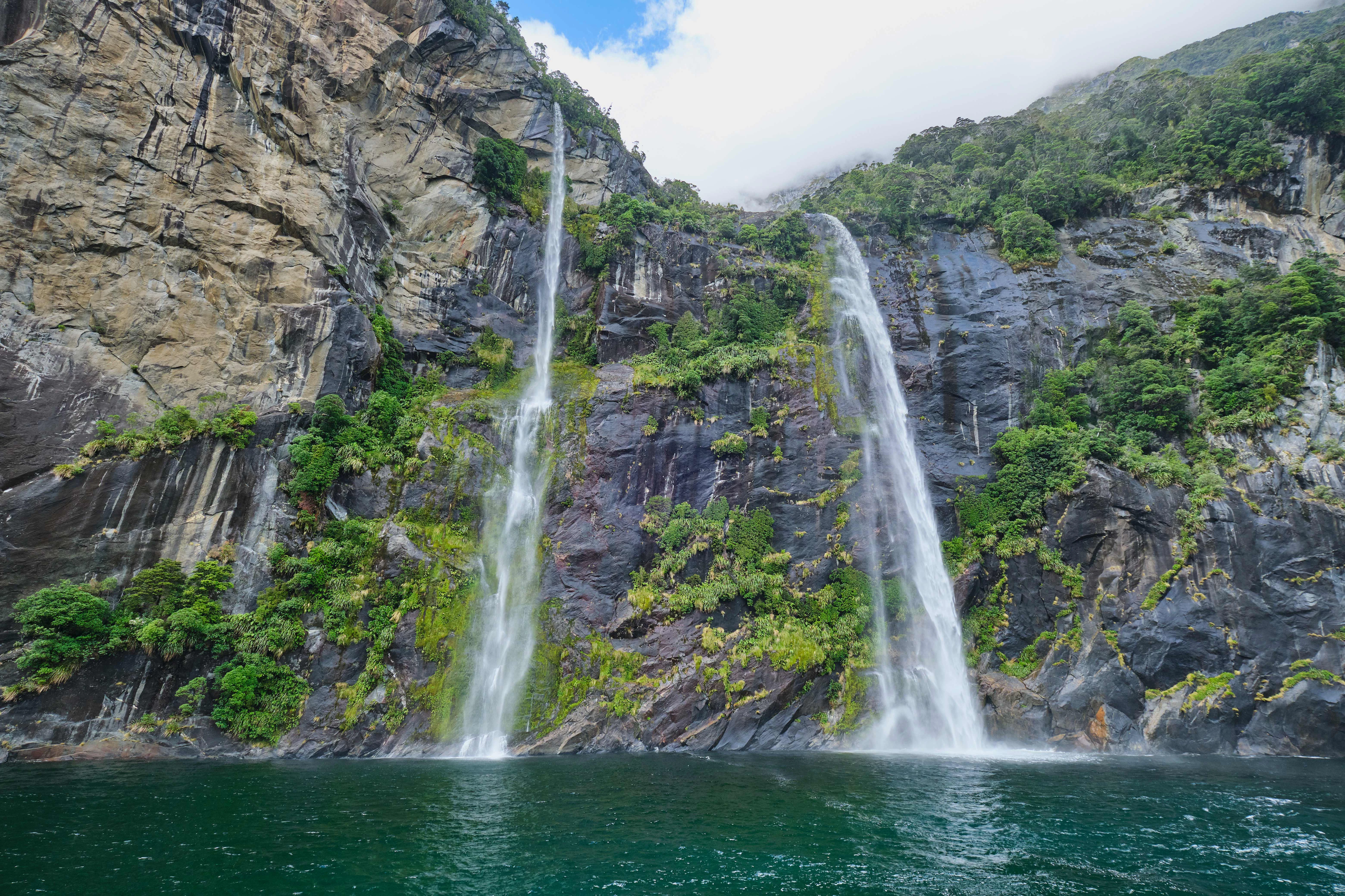 Waterfalls cascading down rocky cliffs at Fairy Falls, Milford Sound.