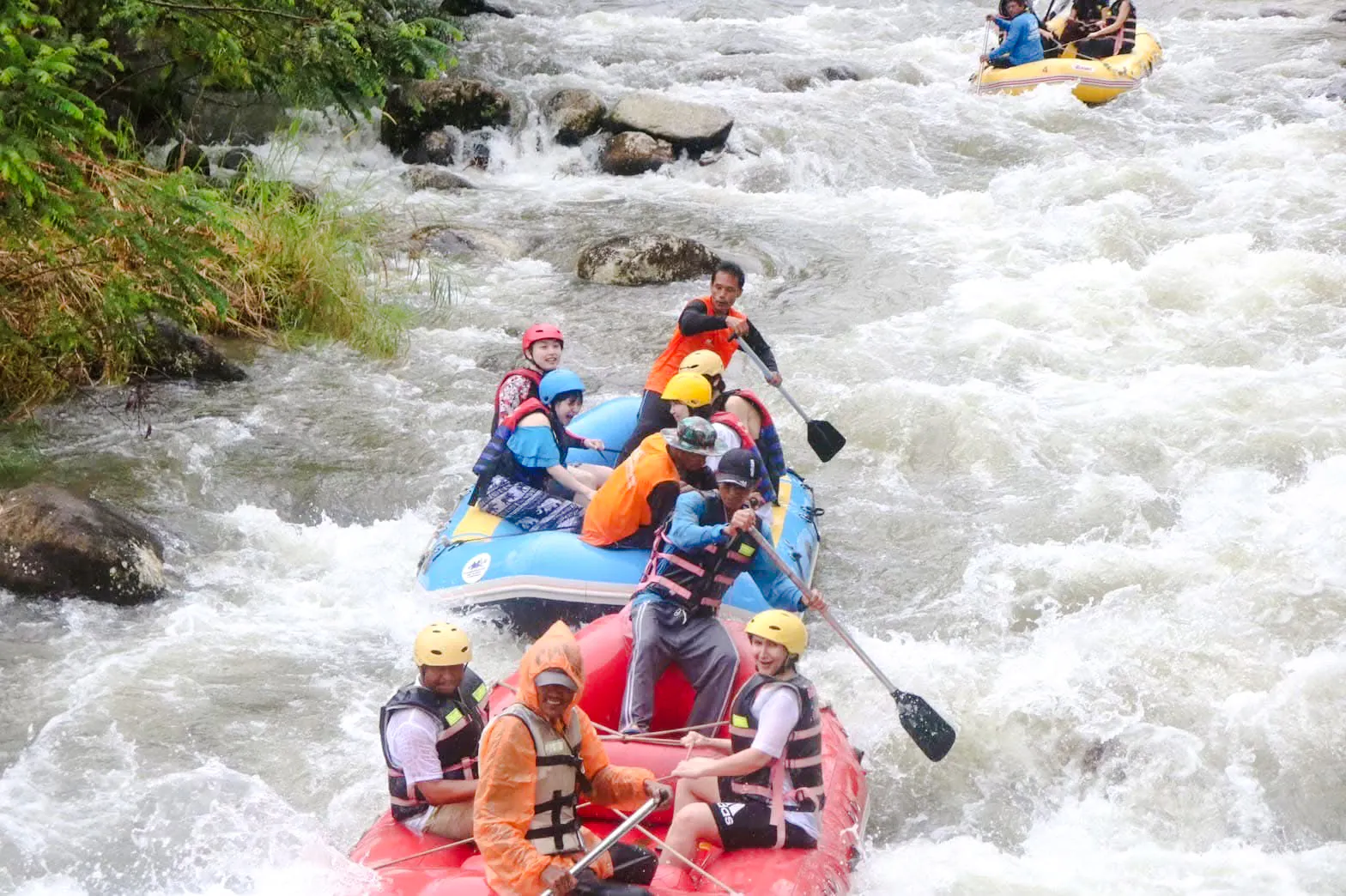 White water rafting adventure on a river in Krabi, with participants navigating rapids.