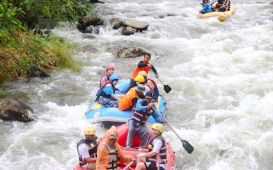 White water rafting adventure on a river in Krabi, with participants navigating rapids.
