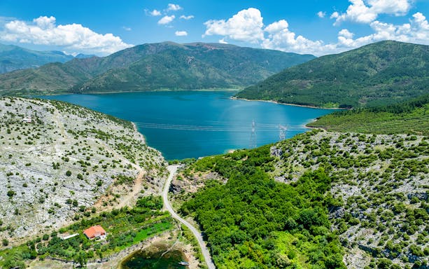 Aerial view of Vau i Dejës Lake surrounded by mountains in Shkoder, Albania.