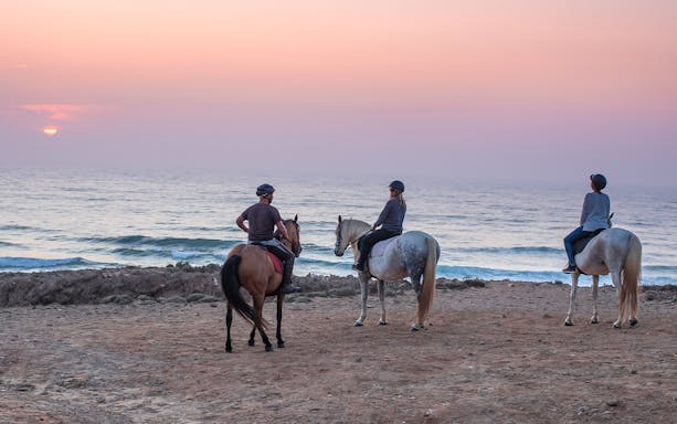 Horse riding along the scenic coastline of Carrapateira, Portugal.