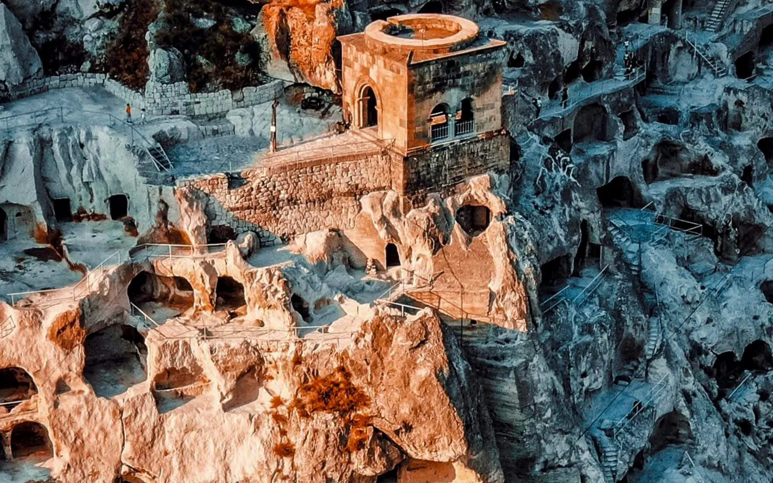 Ruins of Shahr-i-Zohak in Georgia with ancient stone structures and caves.
