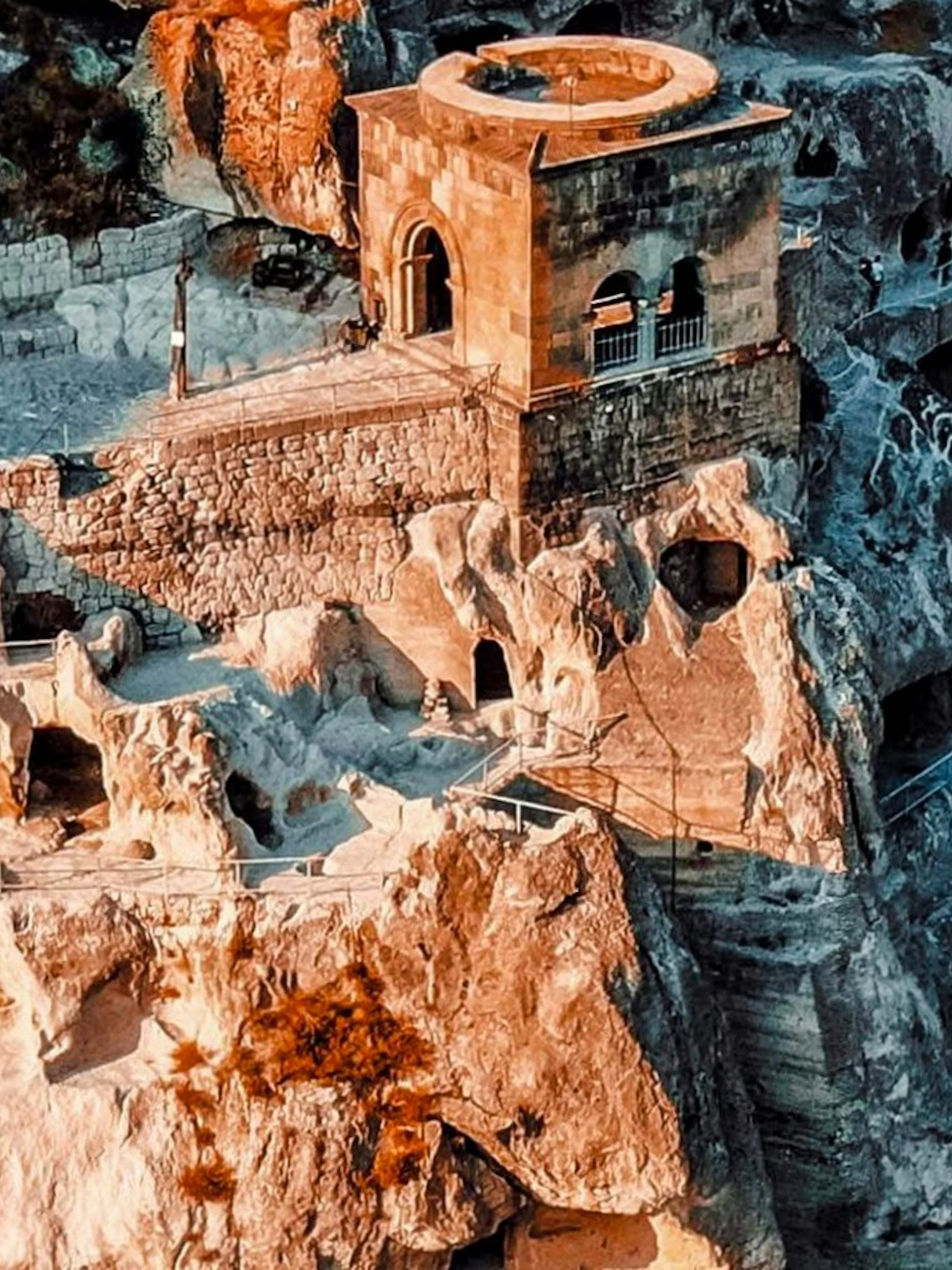 Ruins of Shahr-i-Zohak in Georgia with ancient stone structures and caves.