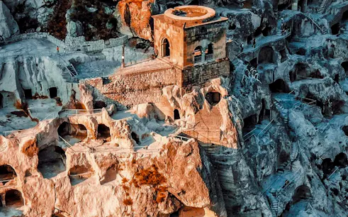 Ruins of Shahr-i-Zohak in Georgia with ancient stone structures and caves.