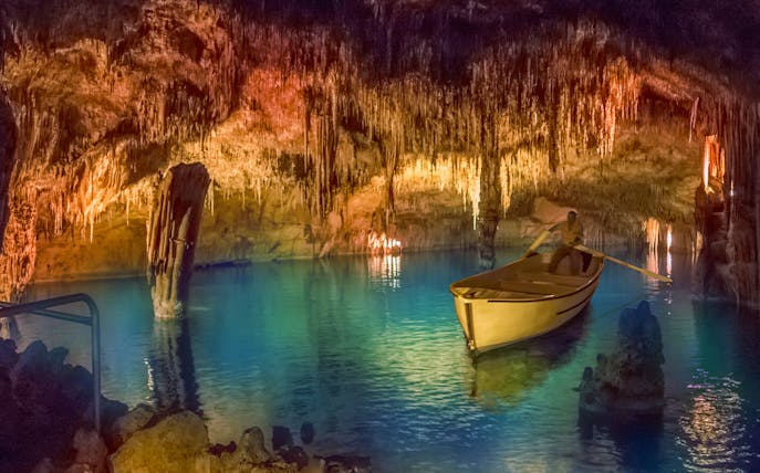 Boat ride through illuminated stalactites in Drach Caves, Mallorca.