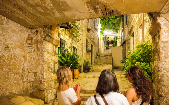 Guests exploring a narrow stone alley in Dubrovnik during a walking tour.