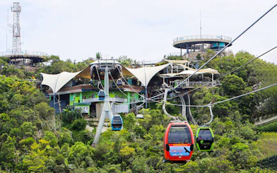 SkyCab cable cars ascending over lush greenery in Langkawi, Malaysia.