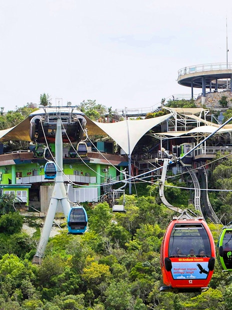 SkyCab cable cars ascending over lush greenery in Langkawi, Malaysia.
