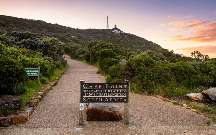 Cape Point sign with coordinates, path leading to lighthouse, Cape of Good Hope, South Africa.