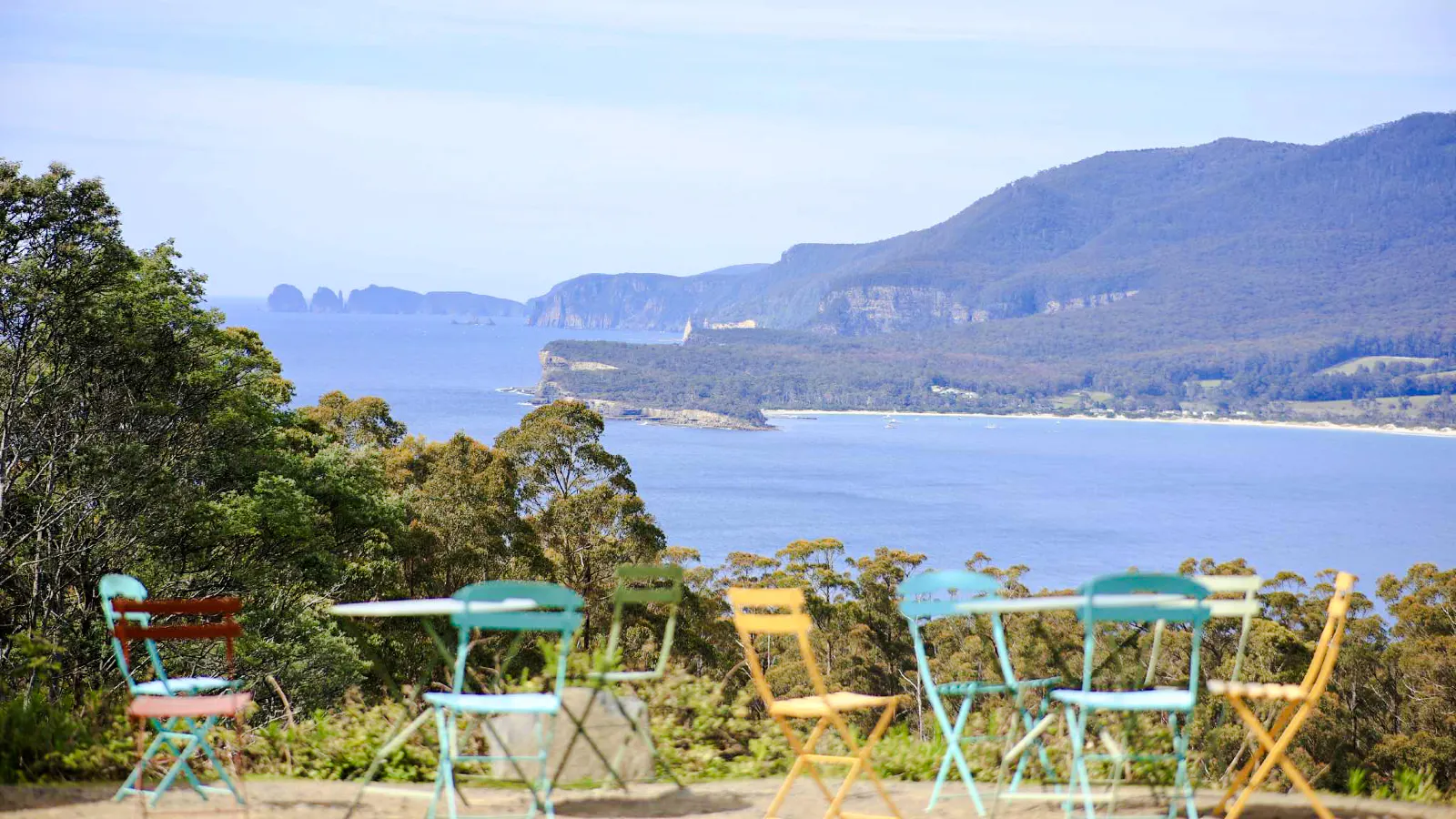 Colorful chairs overlooking Tasman Peninsula coastline, Hobart.