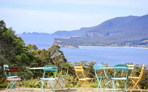 Colorful chairs overlooking Tasman Peninsula coastline, Hobart.