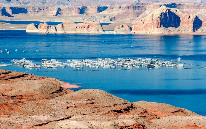 Marina with boats on Lake Mead, surrounded by red rock formations, between Nevada and Arizona.