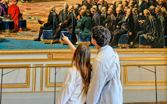Visitors admiring a historical painting inside Versailles Palace during a private guided tour.