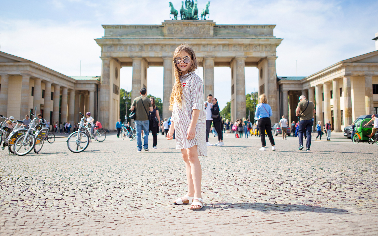 Young girl standing in front of the Brandenburg Gate in Berlin.