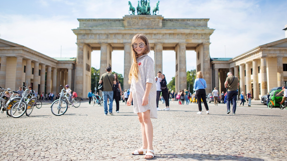 Young girl standing in front of the Brandenburg Gate in Berlin.