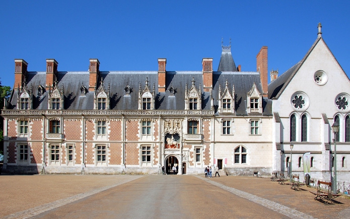 Royal Blois Castle facade with visitors entering through the main entrance.
