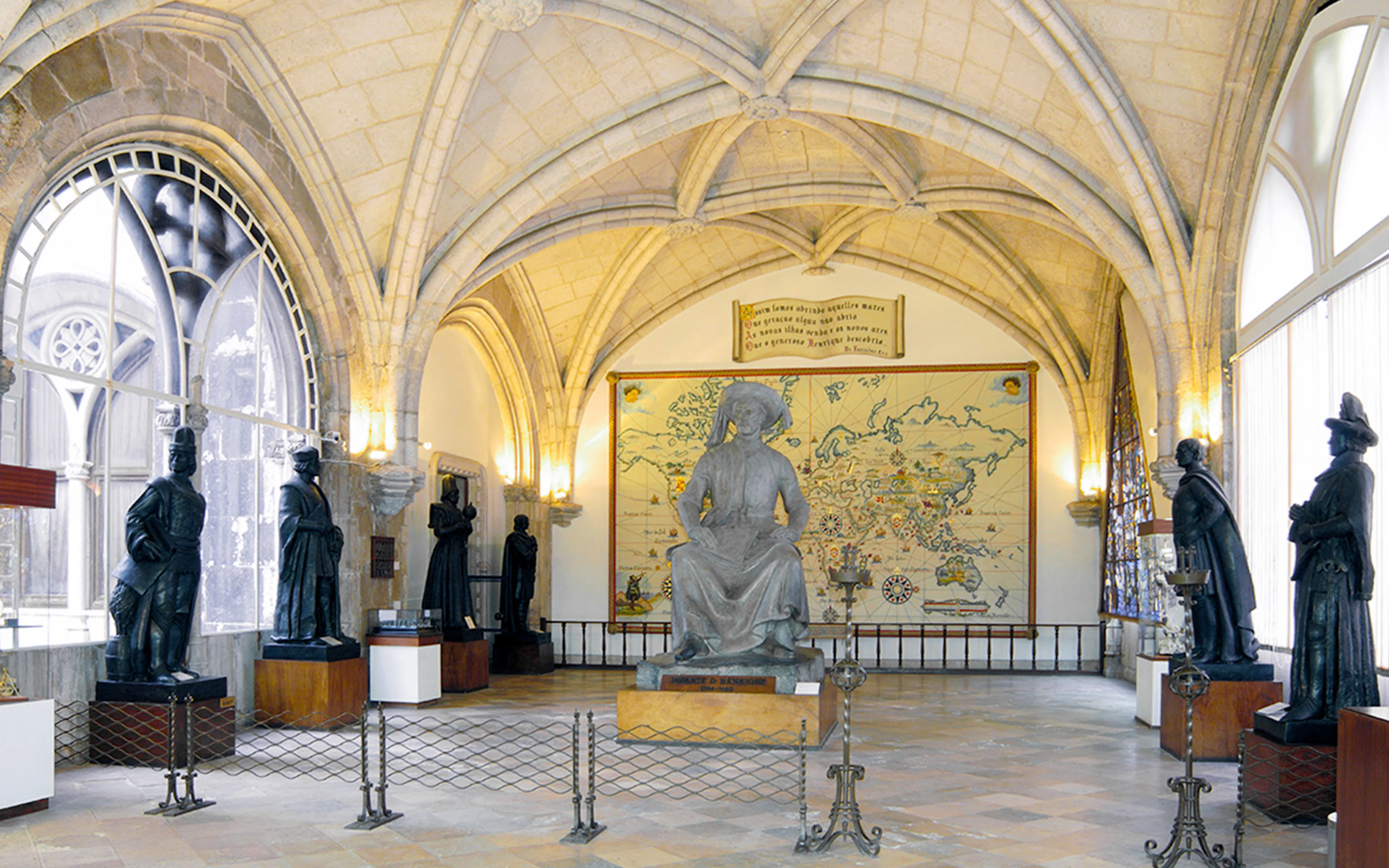 Statues and historical map inside Maritime Museum exhibit hall.