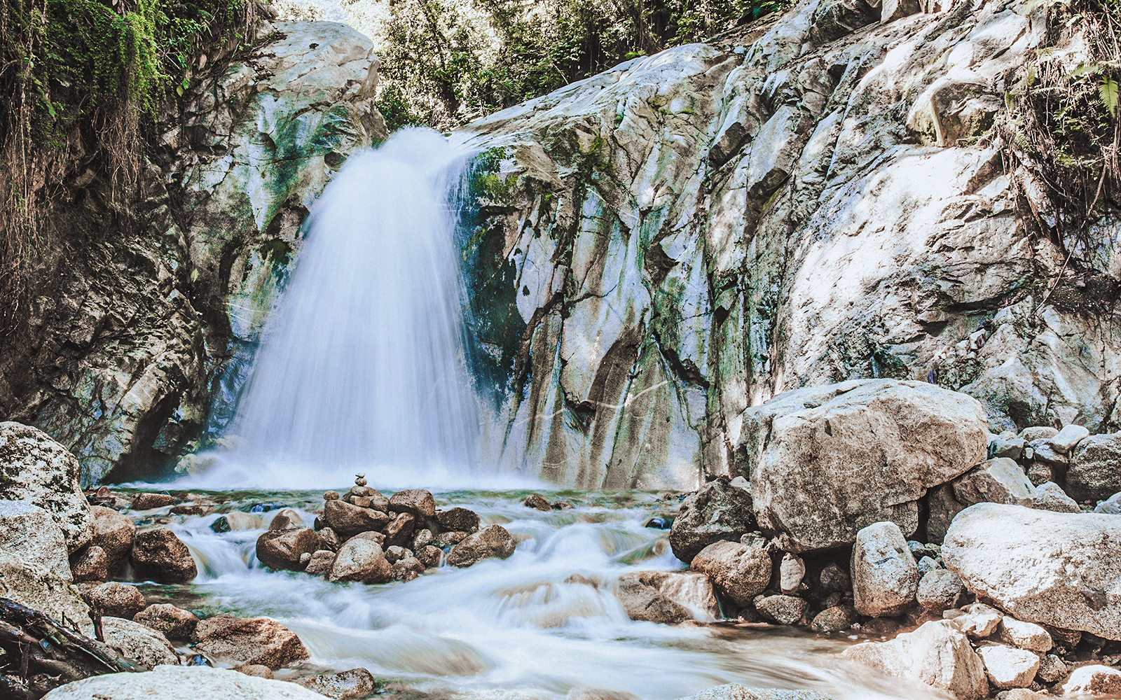 Mandor Waterfall cascading over rocks in a lush forest, Peru.