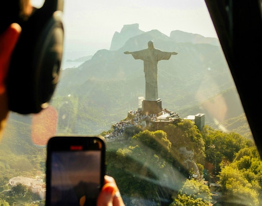Aerial view of Christ the Redeemer statue and Rio de Janeiro coastline from a helicopter.