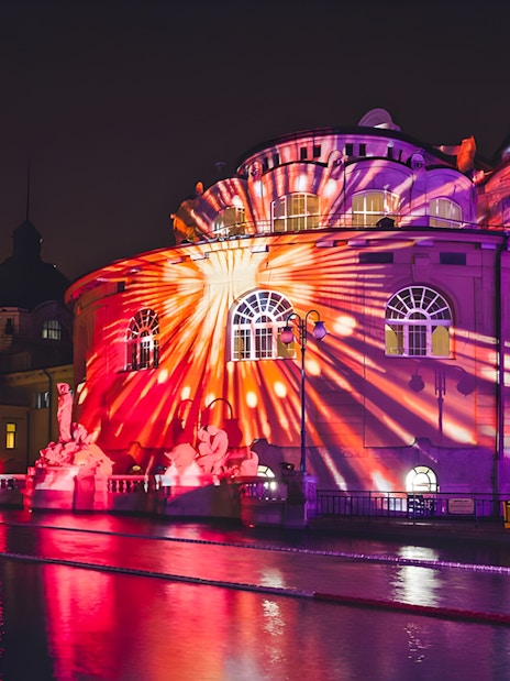 Illuminated building with colorful light projections at night in Budapest, Hungary.