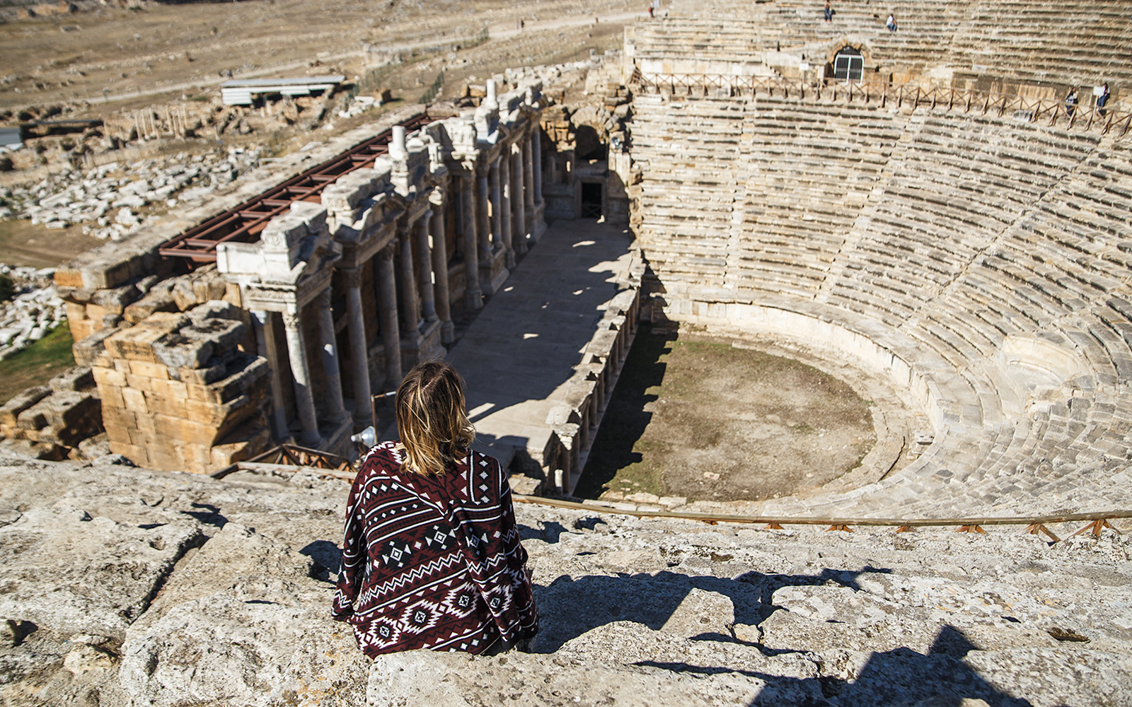 Woman traveler overlooking the ancient amphitheater in Hierapolis, Turkey.
