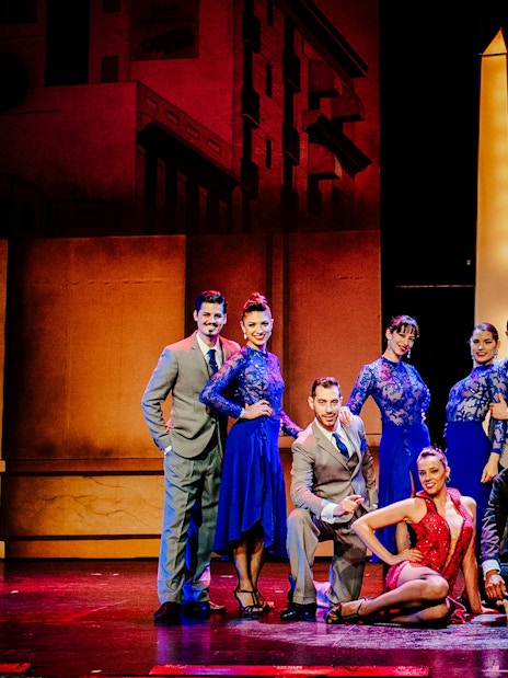 Tango dancers in vibrant costumes at Tango Porteño Show, Buenos Aires stage.
