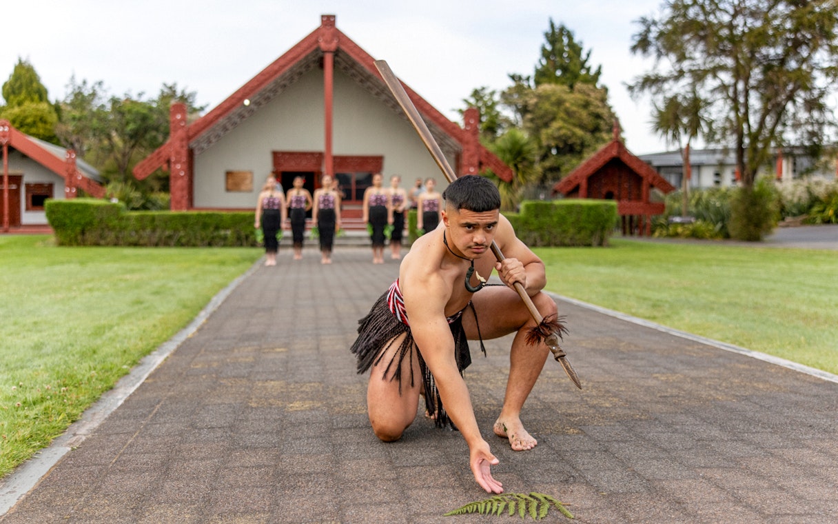 Maori performers in traditional attire performing a haka at Te Puia, Rotorua.