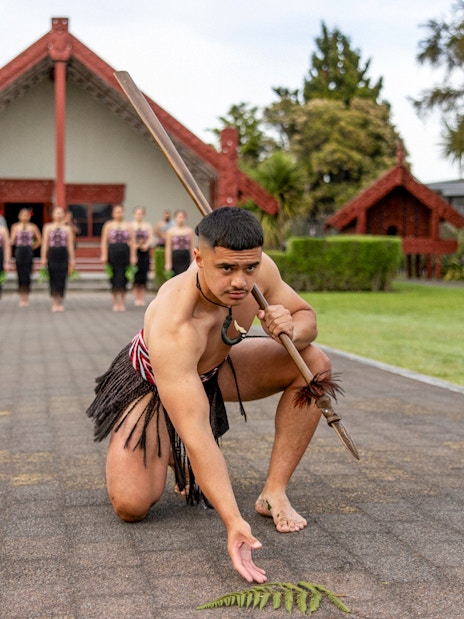 Maori performers in traditional attire performing a haka at Te Puia, Rotorua.