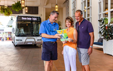Tourists with guide in front of Down Under Tours bus, Kuranda Scenic Railway, Queensland.