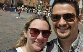 Tourists in Piazza Maggiore, Bologna, with historic buildings in the background.