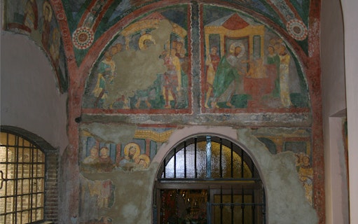 Frescoes inside Basilica of Santa Pudenziana, depicting religious scenes above an arched doorway.