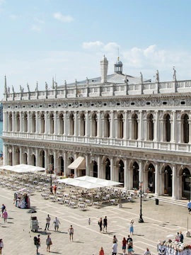 Marciana Library exterior with statues and outdoor seating in Venice, Italy.