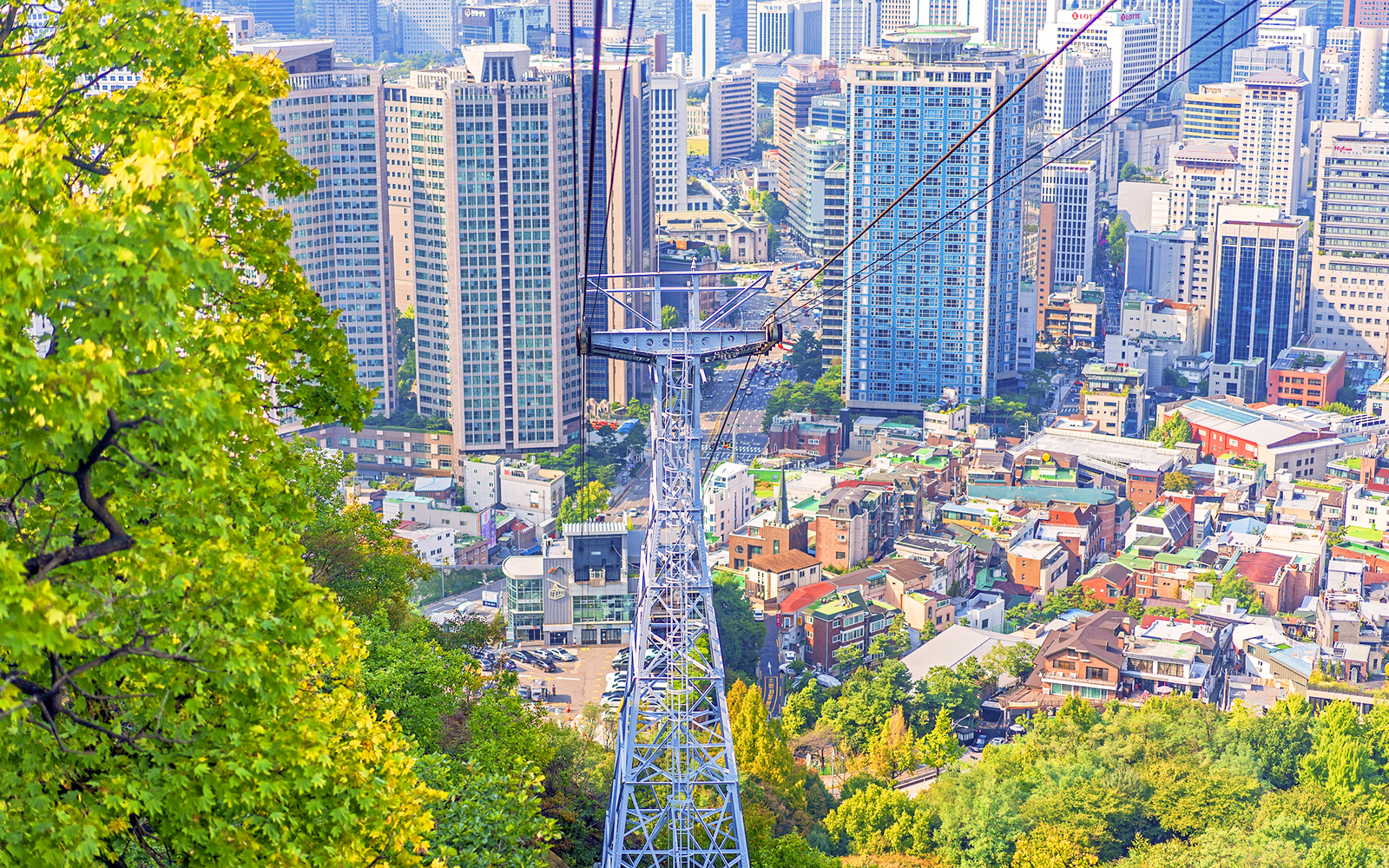 Aerial view of cable car over Namsan with Seoul cityscape.