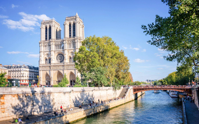 Facade of Notre Dame de Paris with River Seine in Paris, France, seen on a walking tour.