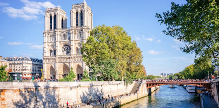 Facade of Notre Dame de Paris with River Seine in Paris, France, seen on a walking tour.