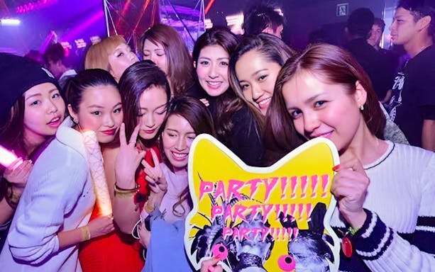 Group enjoying nightlife at KITSUNE Kyoto Nightclub with party sign.