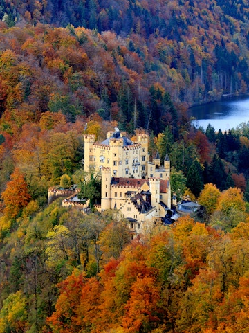 Hohenschwangau Castle surrounded by autumn foliage in Bavaria, Germany.