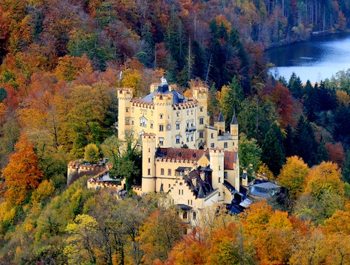 Hohenschwangau Castle surrounded by autumn foliage in Bavaria, Germany.